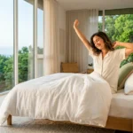 A person waking up refreshed in a bright bedroom represents healthy sleep habits and overall sleep health.